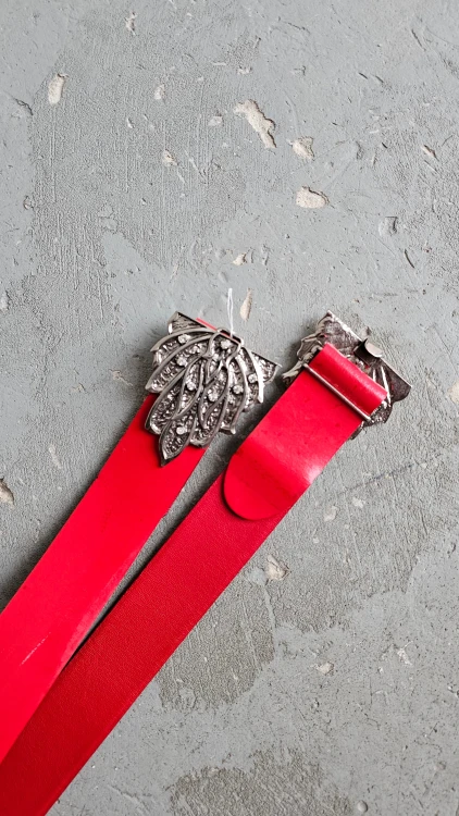 Czerwony pasek skórzany vintage z ozdobną klamrą